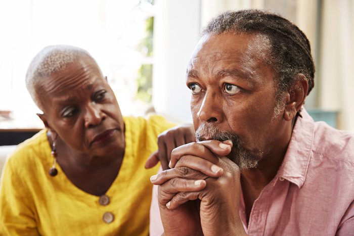 senior African American couple - woman comforting man - older adults