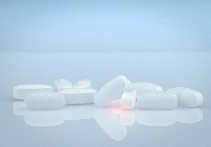 small pile of Vicodin tablets on a white glossy table