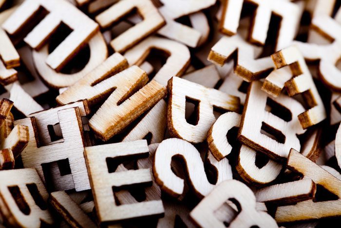 closeup of a jumbled stack of wooden alphabet letters - personalized care