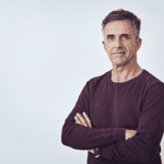 A man with his arms folded, looking confident.