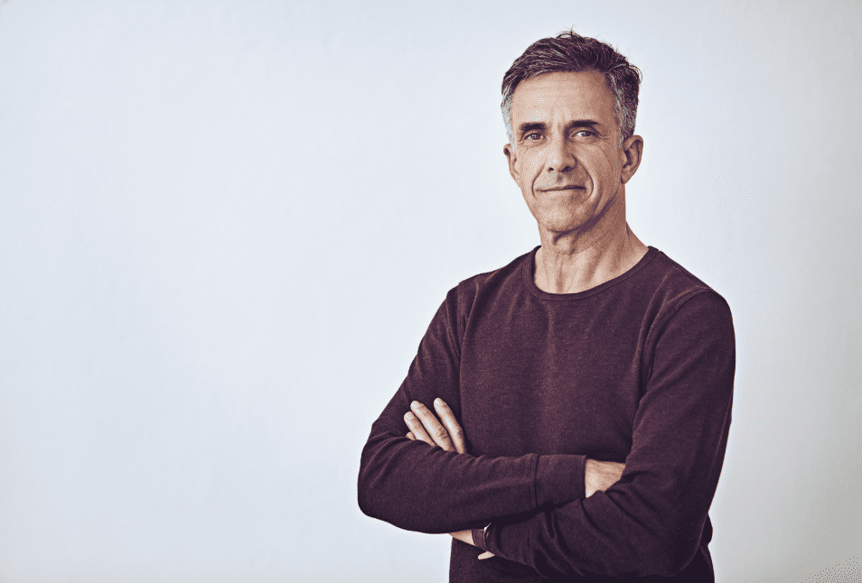 A man with his arms folded, looking confident.