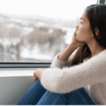 A woman looking outside at a winter day.