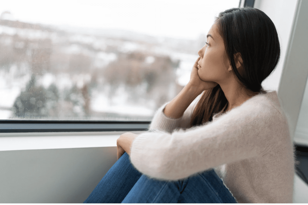 A woman looking outside at a winter day.